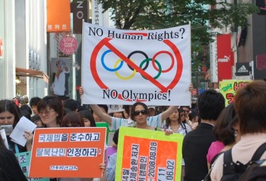 Protester inför Peking-OS. Bilden lånad från http://ohkelly.wordpress.com/2008/08/17/an-event-that-stops-the-worldbut-does-it/
